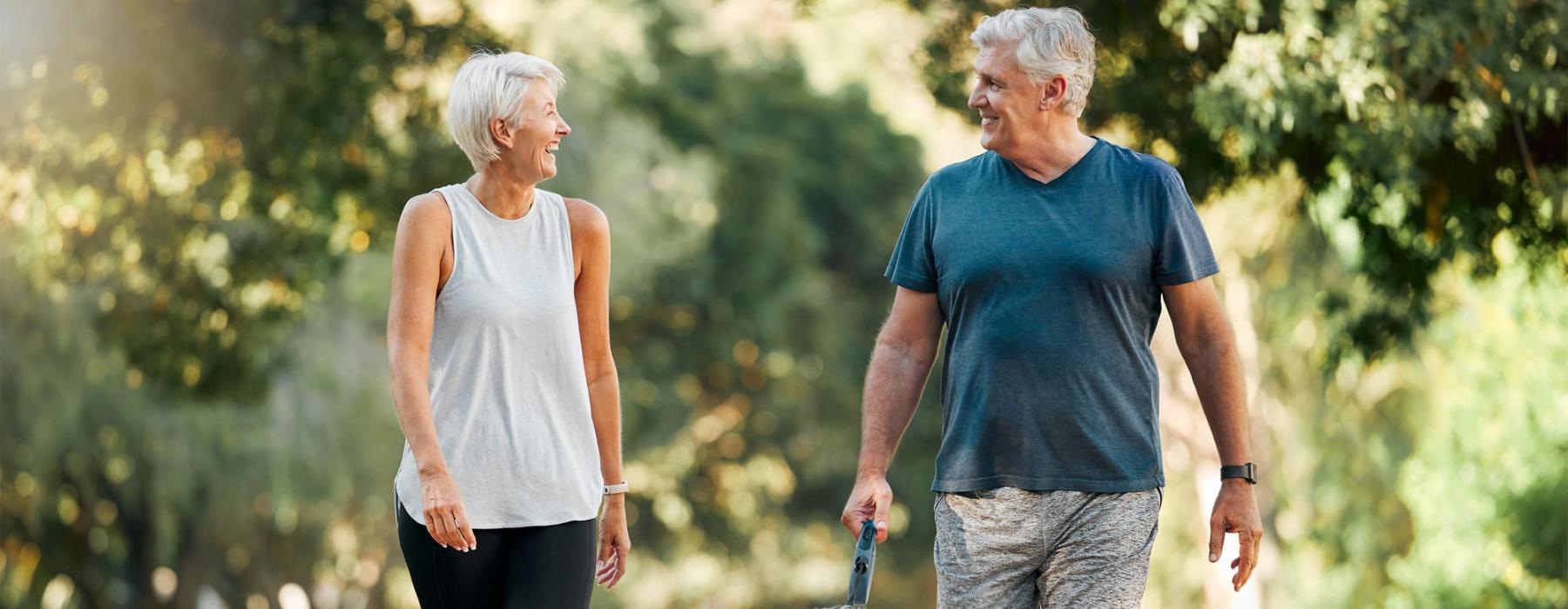 a man and a woman walking a dog on a leash